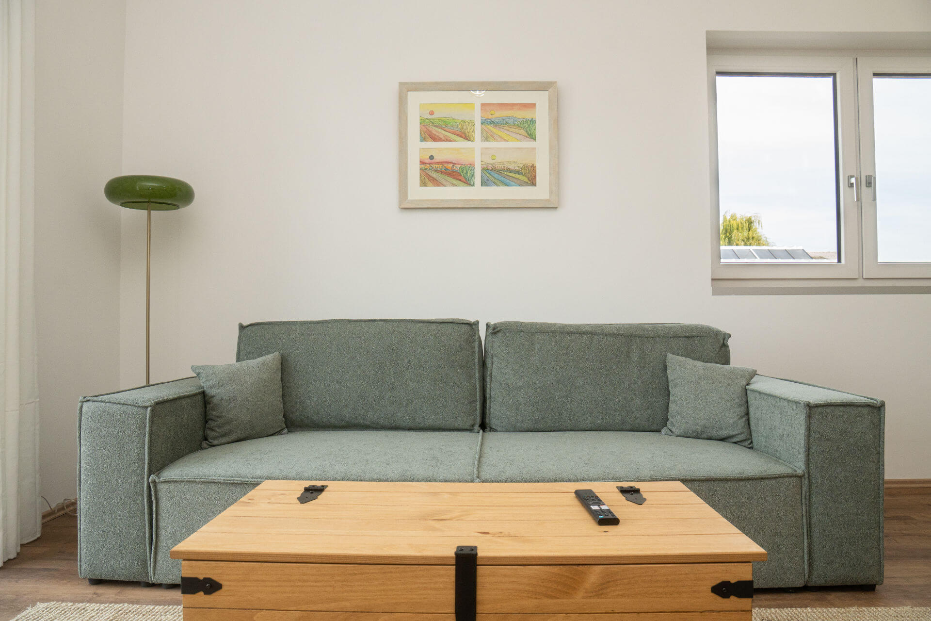 Grünes Sofa mit Holztruhe als Couchtisch